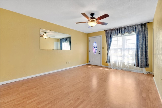 foyer featuring ceiling fan, light hardwood / wood-style floors, and a textured ceiling