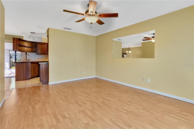 unfurnished living room with ceiling fan and light wood-type flooring