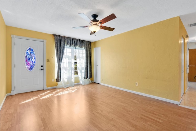 entryway with ceiling fan, a textured ceiling, and light wood-type flooring