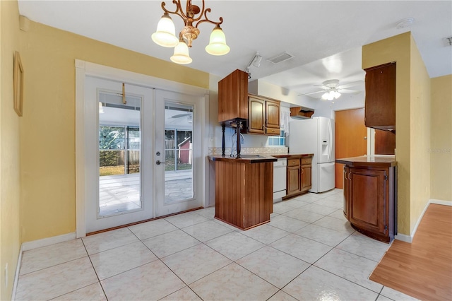 kitchen with french doors, sink, hanging light fixtures, light tile patterned floors, and white appliances