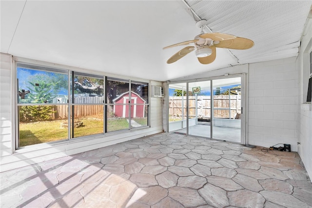 unfurnished sunroom with ceiling fan, a healthy amount of sunlight, and a wall mounted AC