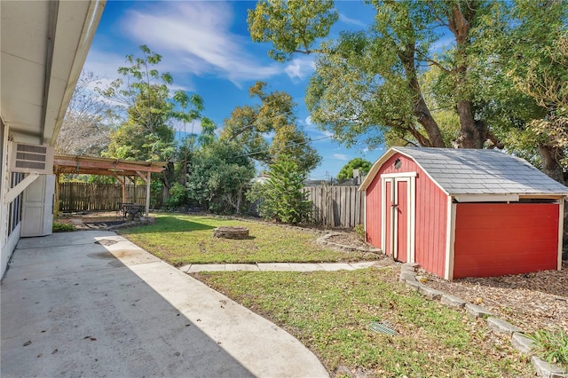 view of yard featuring a fire pit, a patio, and a storage unit