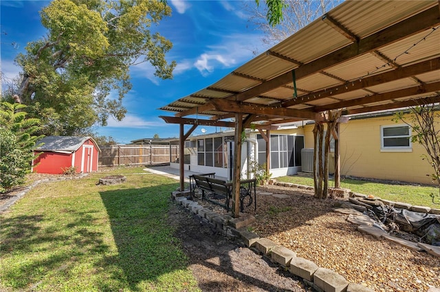 view of yard with a patio, a storage unit, a sunroom, and a fire pit