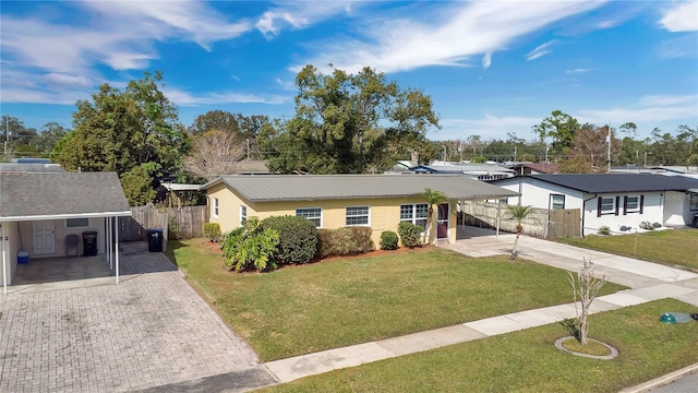 ranch-style house featuring a front yard and a carport