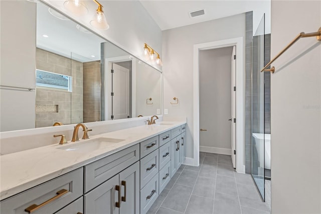 bathroom featuring vanity, tiled shower, and tile patterned floors