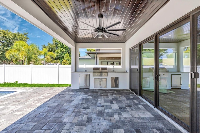 view of patio with sink, ceiling fan, exterior kitchen, and area for grilling