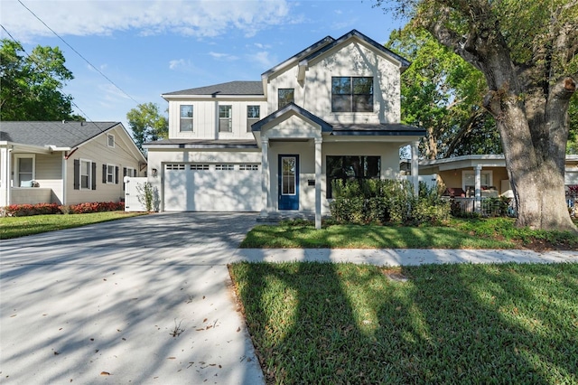 view of front of home featuring a garage, a front yard, driveway, and stucco siding