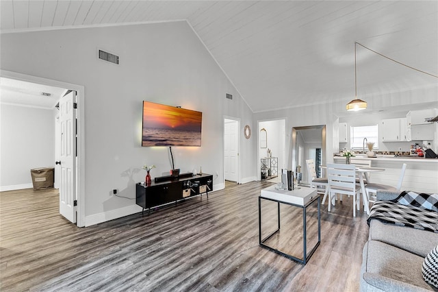 living room featuring light hardwood / wood-style floors, sink, and high vaulted ceiling