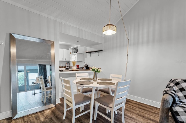 dining room featuring vaulted ceiling and dark wood-type flooring