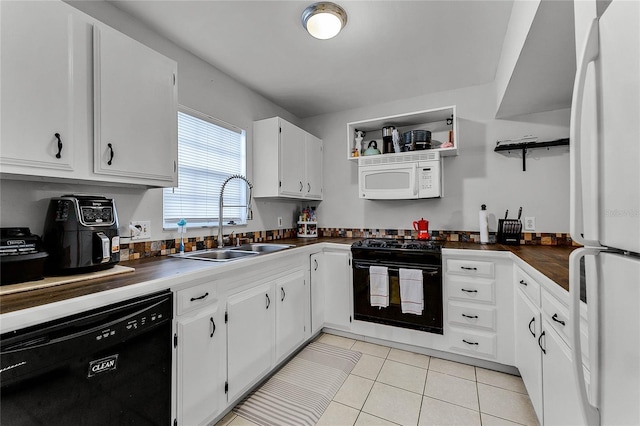 kitchen featuring sink, black appliances, white cabinetry, and light tile patterned floors