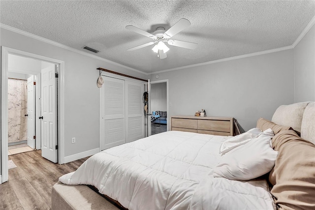 bedroom featuring crown molding, light hardwood / wood-style floors, a textured ceiling, a closet, and ceiling fan