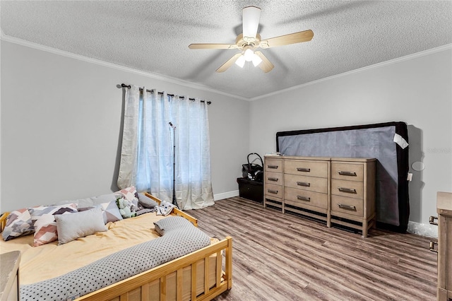 bedroom featuring ceiling fan, crown molding, a textured ceiling, and wood-type flooring