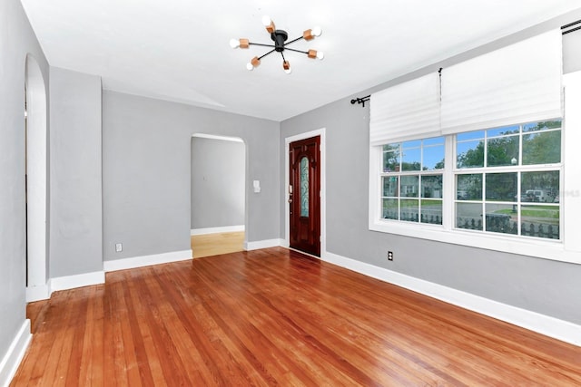 foyer with wood-type flooring and a chandelier