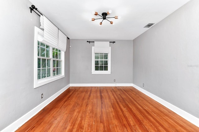 unfurnished room with hardwood / wood-style flooring