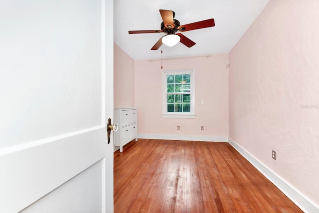 empty room with hardwood / wood-style floors and ceiling fan