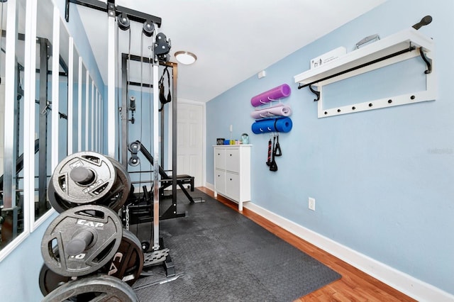 exercise room featuring dark hardwood / wood-style flooring and lofted ceiling