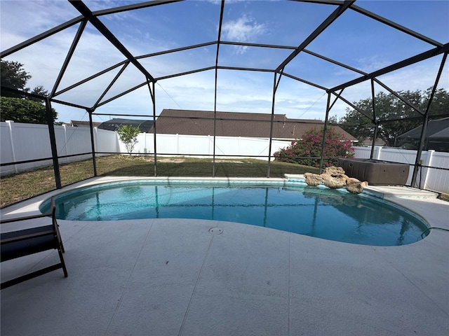 view of pool featuring a patio, glass enclosure, and a hot tub