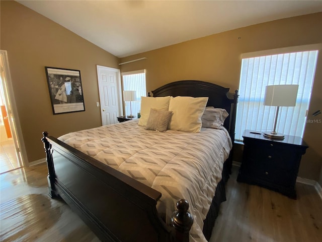 bedroom with wood-type flooring and lofted ceiling