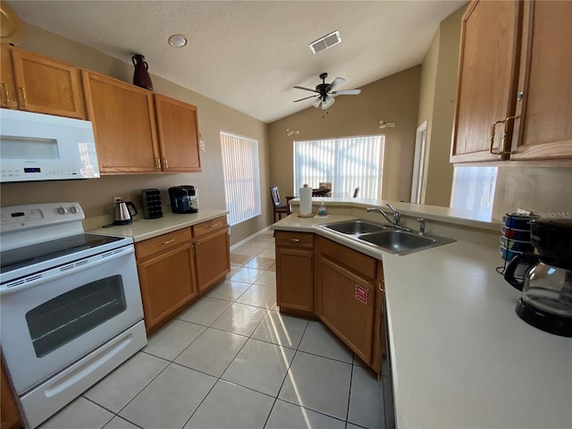 kitchen with vaulted ceiling, ceiling fan, sink, light tile patterned floors, and white appliances