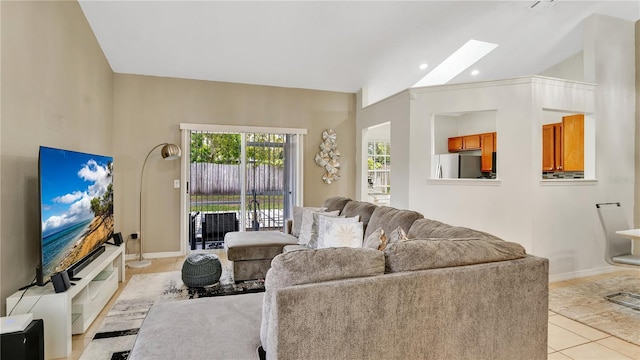 living room featuring light tile patterned floors and lofted ceiling with skylight