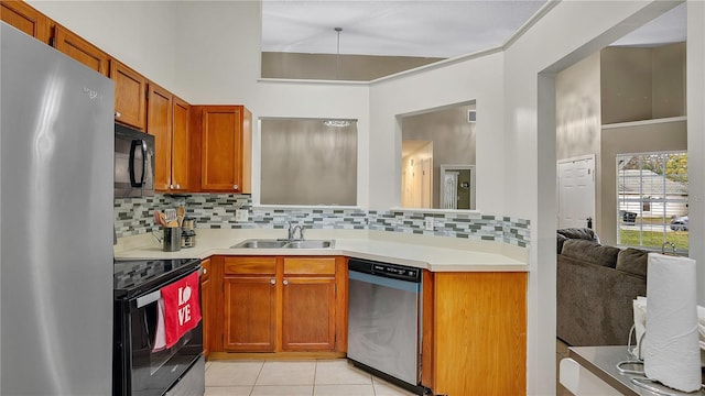 kitchen featuring light tile patterned flooring, sink, black appliances, and tasteful backsplash