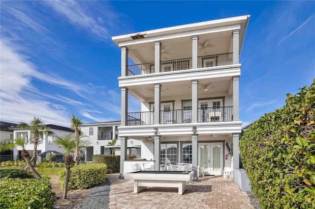 view of front facade with a patio, french doors, a balcony, and ceiling fan