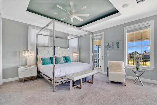 bedroom with access to exterior, a tray ceiling, light colored carpet, and ceiling fan