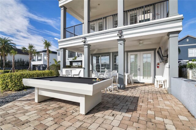 view of patio featuring a bar, french doors, and a balcony