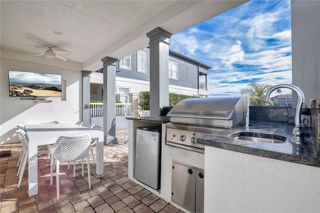 view of patio / terrace featuring an outdoor wet bar, grilling area, ceiling fan, and an outdoor kitchen