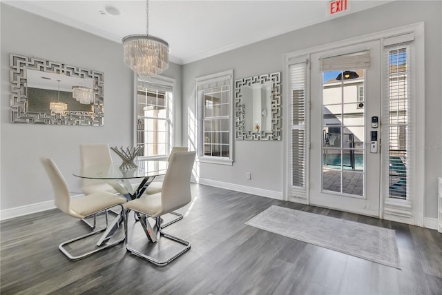 dining room with an inviting chandelier, crown molding, and dark wood-type flooring