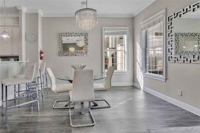 dining area with ornamental molding, dark hardwood / wood-style flooring, and a chandelier