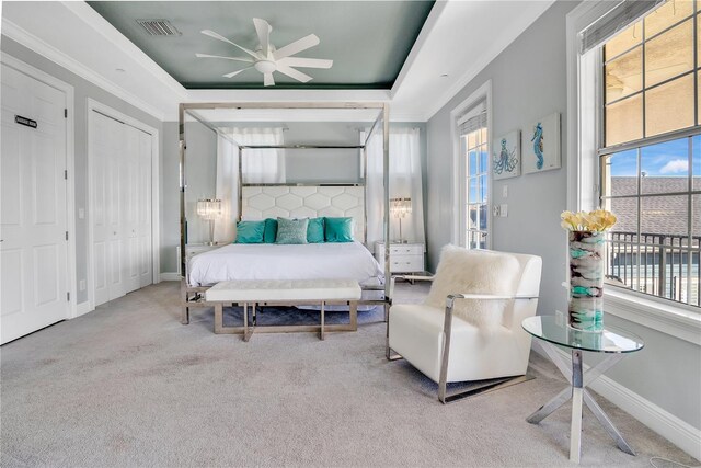 carpeted bedroom featuring ornamental molding and a raised ceiling