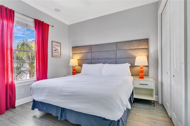 bedroom with ornamental molding, a closet, and light wood-type flooring