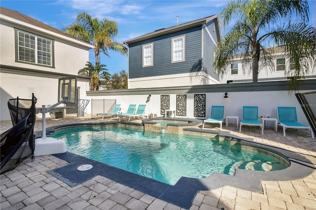 back of house featuring a pool with hot tub and a patio