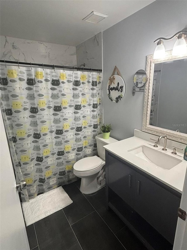 bathroom featuring vanity, tile patterned flooring, toilet, and walk in shower