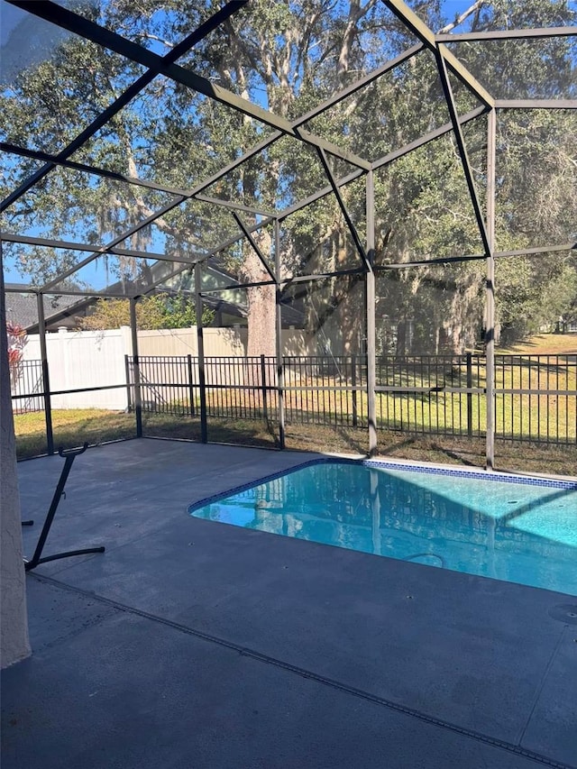 view of swimming pool featuring a patio and glass enclosure