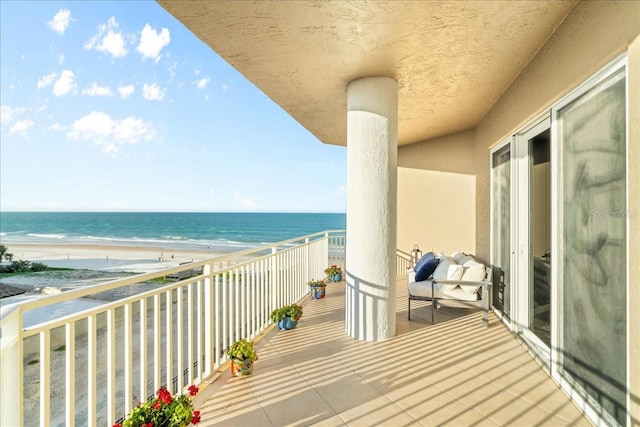 balcony featuring a water view and a view of the beach