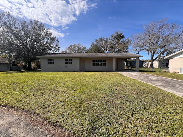 ranch-style house featuring a front lawn and a carport