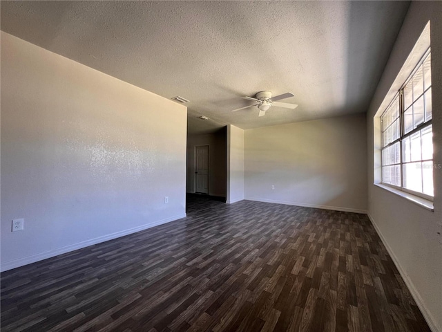 spare room with a textured ceiling, ceiling fan, and dark hardwood / wood-style flooring