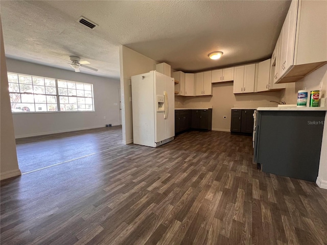 kitchen with a textured ceiling, white cabinetry, white refrigerator with ice dispenser, dark hardwood / wood-style floors, and ceiling fan