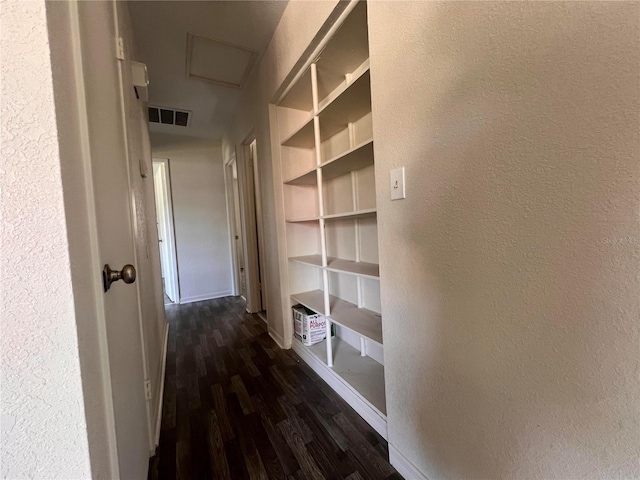 hallway with built in shelves and dark hardwood / wood-style floors