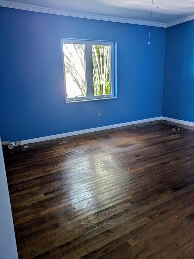 empty room featuring ornamental molding and dark hardwood / wood-style flooring