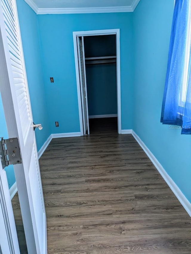 unfurnished bedroom with dark hardwood / wood-style floors, a closet, and crown molding