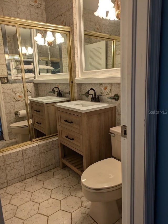 bathroom featuring vanity, toilet, and an inviting chandelier