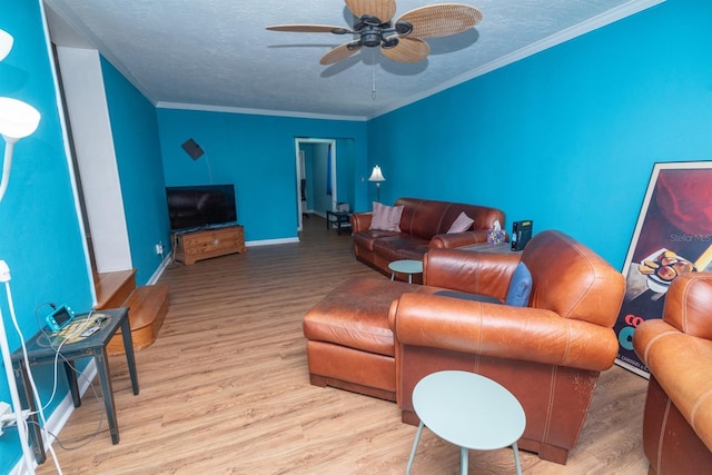 living room with ceiling fan, a textured ceiling, light hardwood / wood-style flooring, and ornamental molding