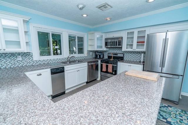 kitchen with tile patterned flooring, appliances with stainless steel finishes, sink, white cabinets, and tasteful backsplash