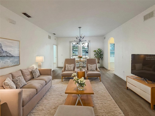 carpeted living room with an inviting chandelier