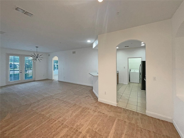 unfurnished room with light colored carpet and washer / clothes dryer