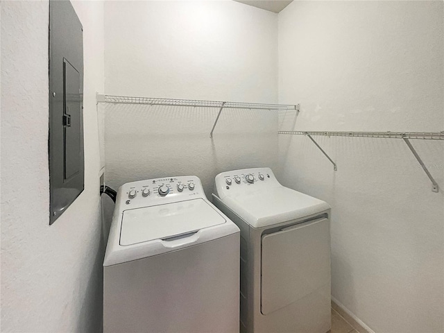 clothes washing area with washer and clothes dryer and electric panel