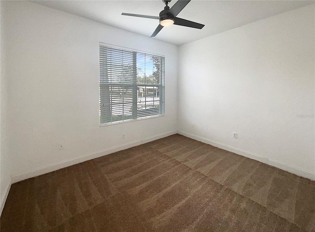 unfurnished room with ceiling fan and dark colored carpet